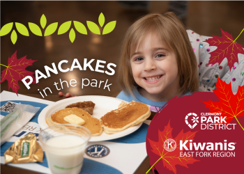 young park-goer smiling with her stack of pancakes with cartoon maple leaves and white text that reads "pancakes in the park"